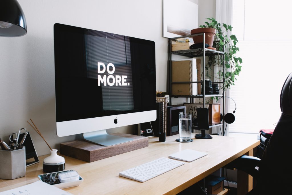 Tech tools and modern technology ease career advancement for people with disabilities. Photo image of Silver iMac with track pad on a desk.